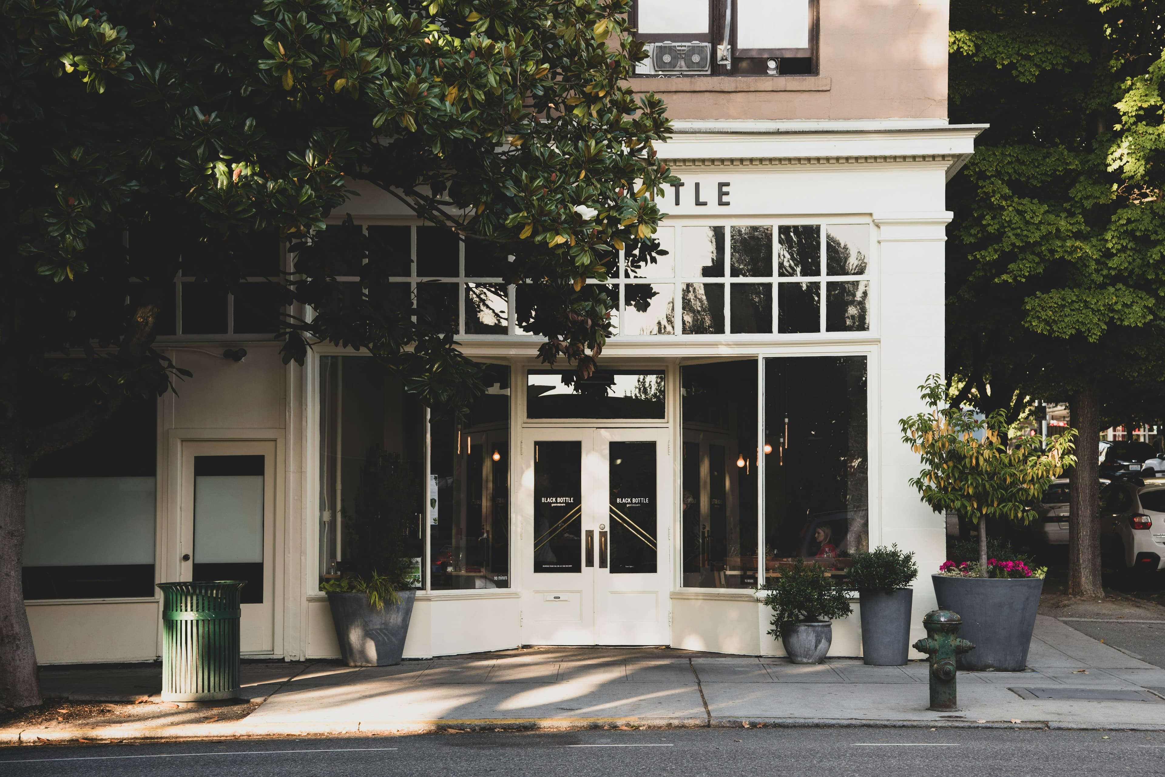 A classic small-business storefront with large windows and street-level plants.
