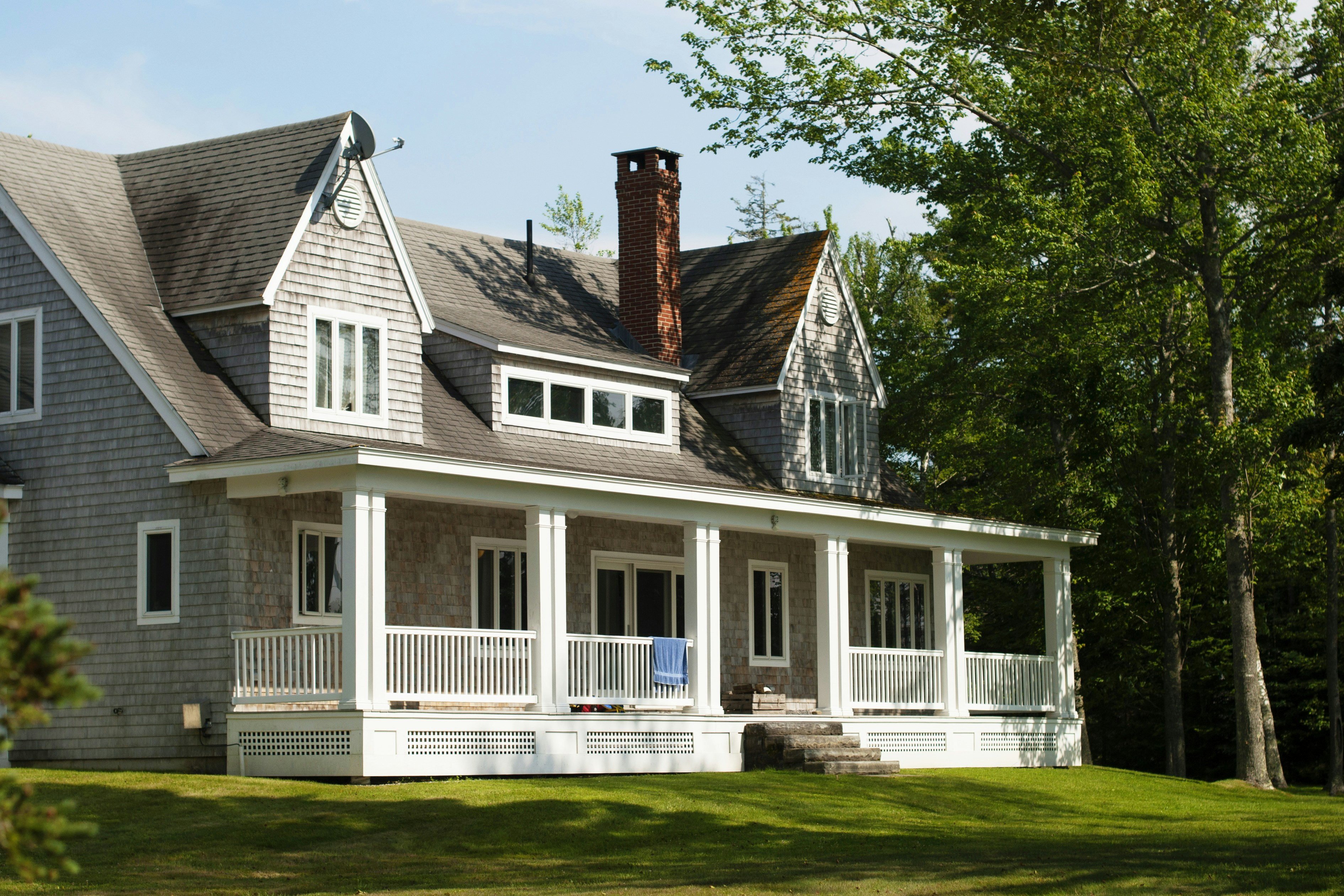 A classic shingle-style home with a wraparound porch.