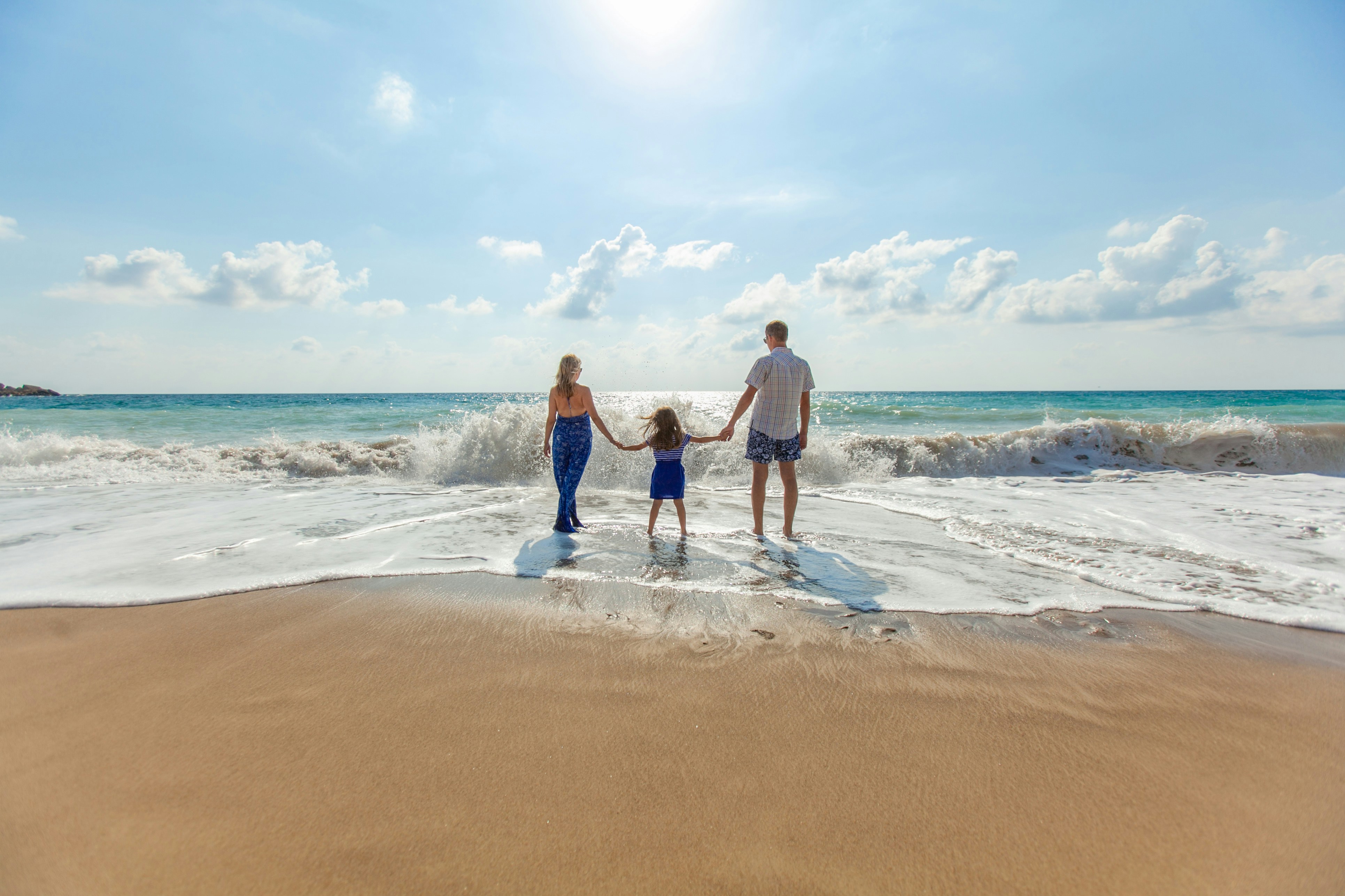 A family walking together along the shoreline.