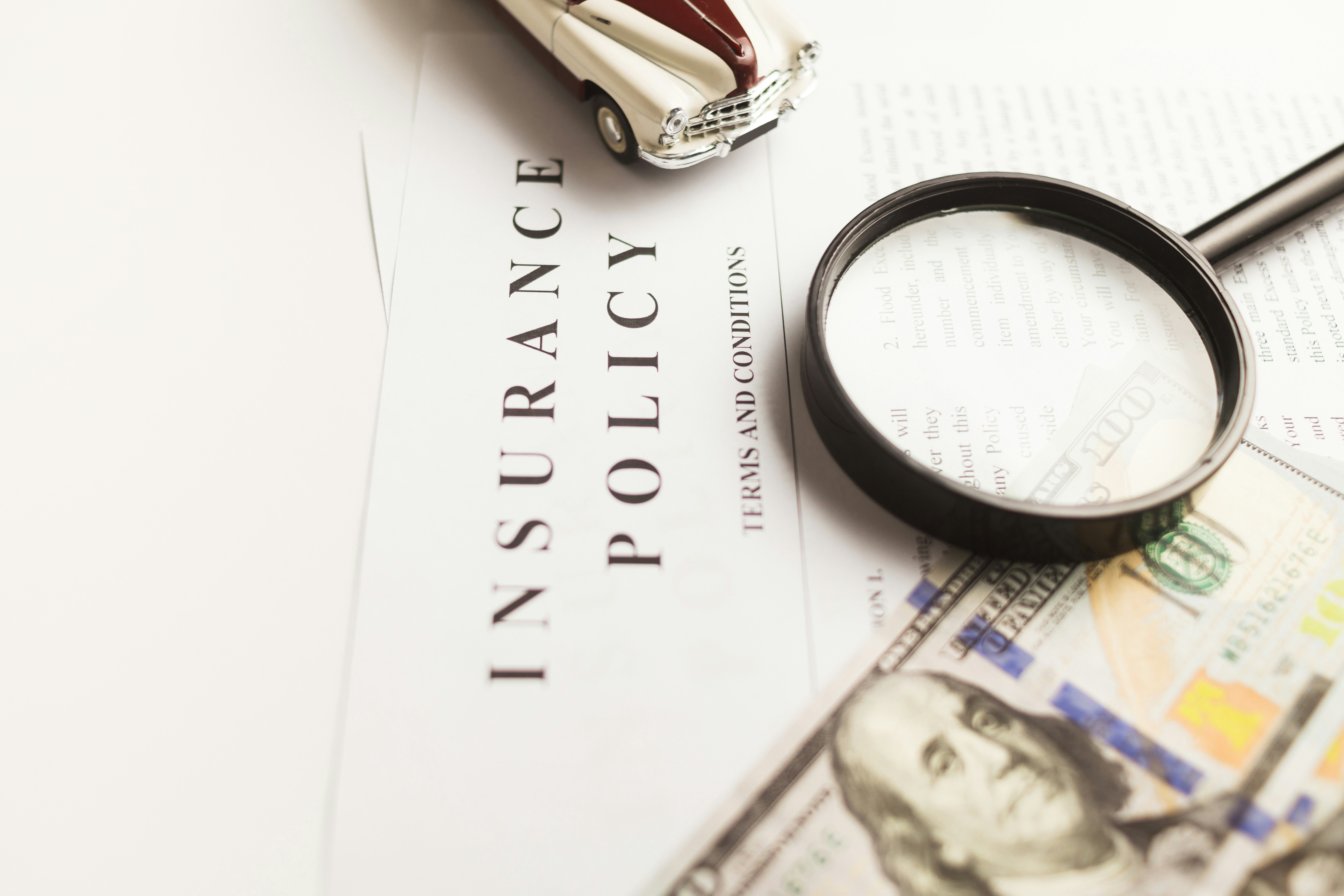 An insurance policy document reviewed under a magnifying glass.